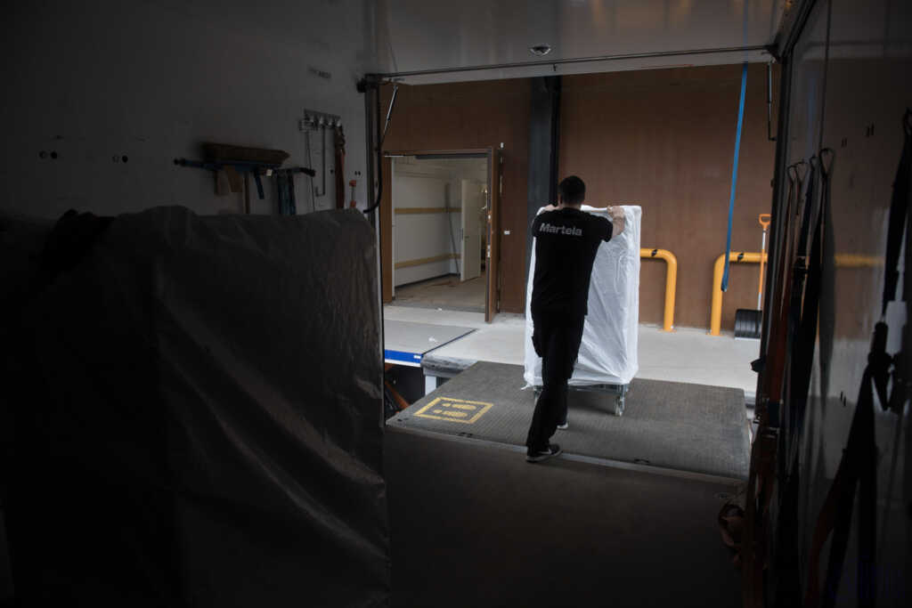 Muuttopalvelu siirtää tavaraa kuorma-autosta rakennukseen